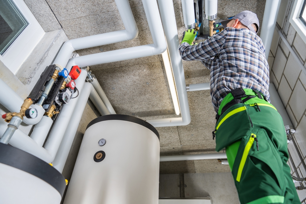 A boiler repairman fixing an industrial boiler