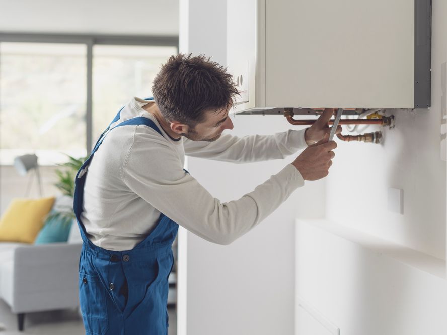 A plumber fixing a boiler