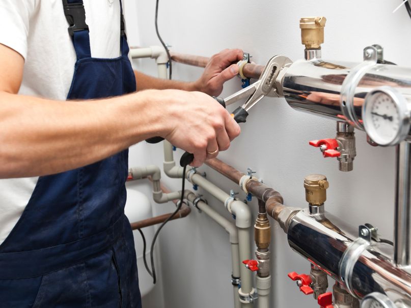 A complex boiler system being serviced by a plumber